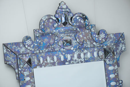 Decorative mirror with intricate patterns on a white background