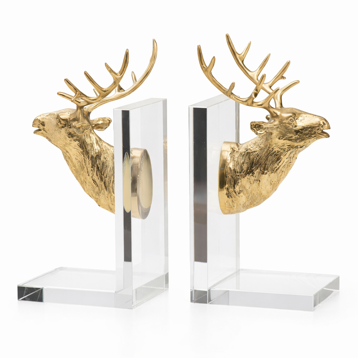 Two gold deer head bookends on clear stands against a white background