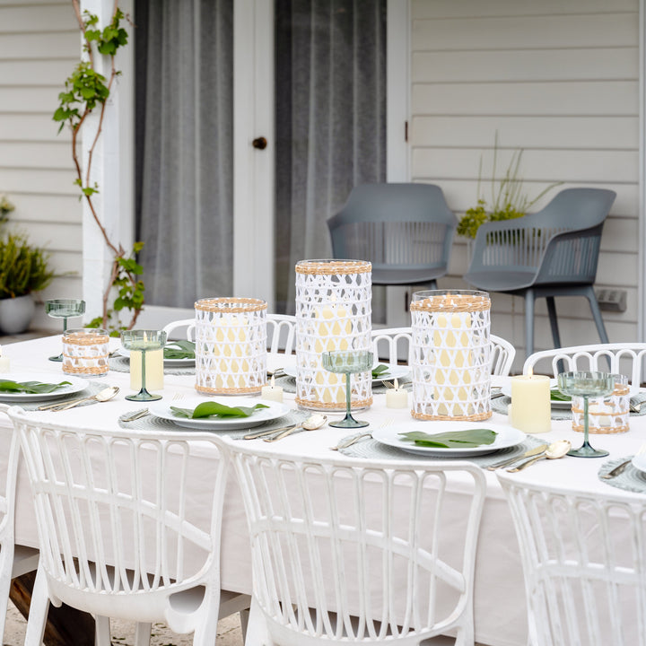 Outdoor dining setup with a table, chairs, and decorative elements on a patio.
