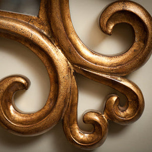 Close-up of ornate gold decorative element on a beige background